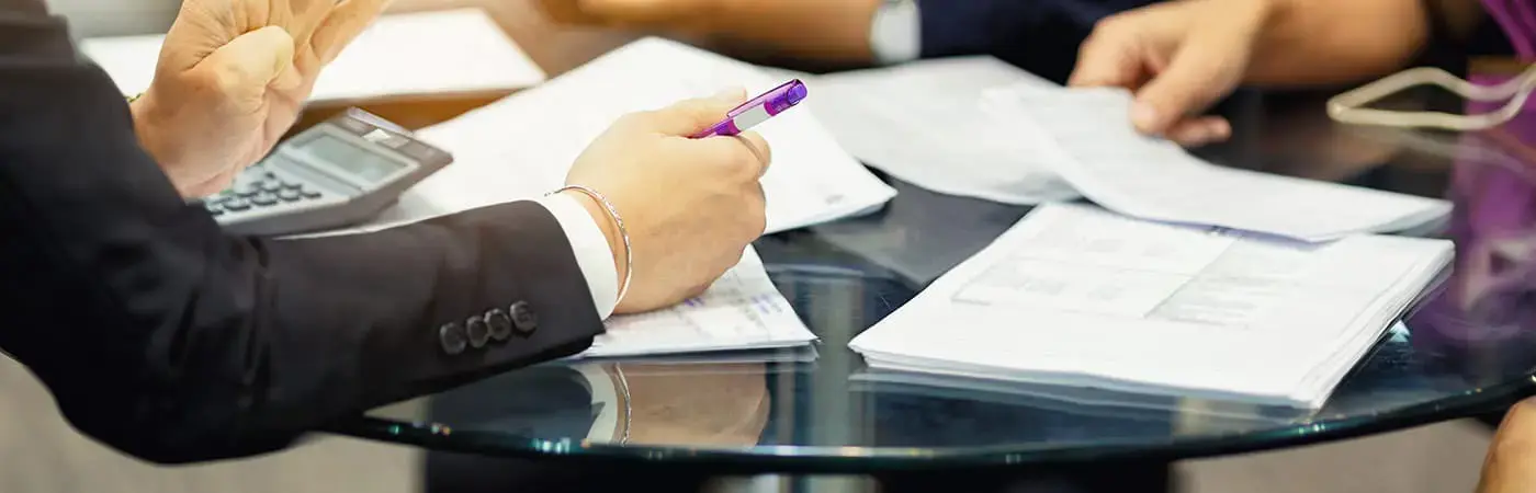 a close up of a business meeting with notes and a calculator