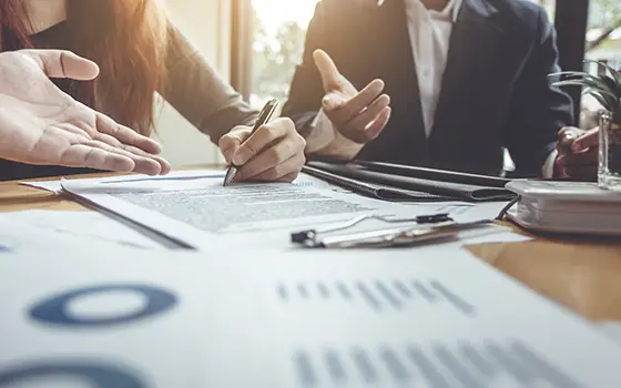 a man and a women discussing and signing business contracts a man and a women discussing and signing business contracts